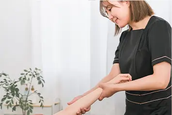 腕のエステをするエステティシャン